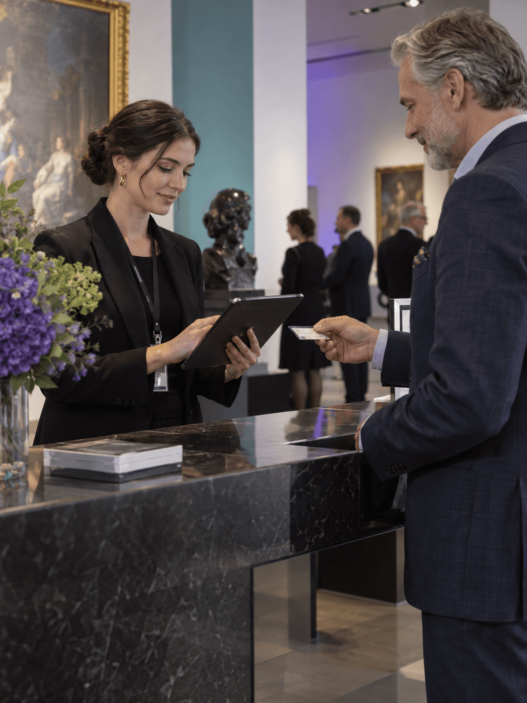 An auction registrar verifies a bidder’s registration at a contemporary auction house reception